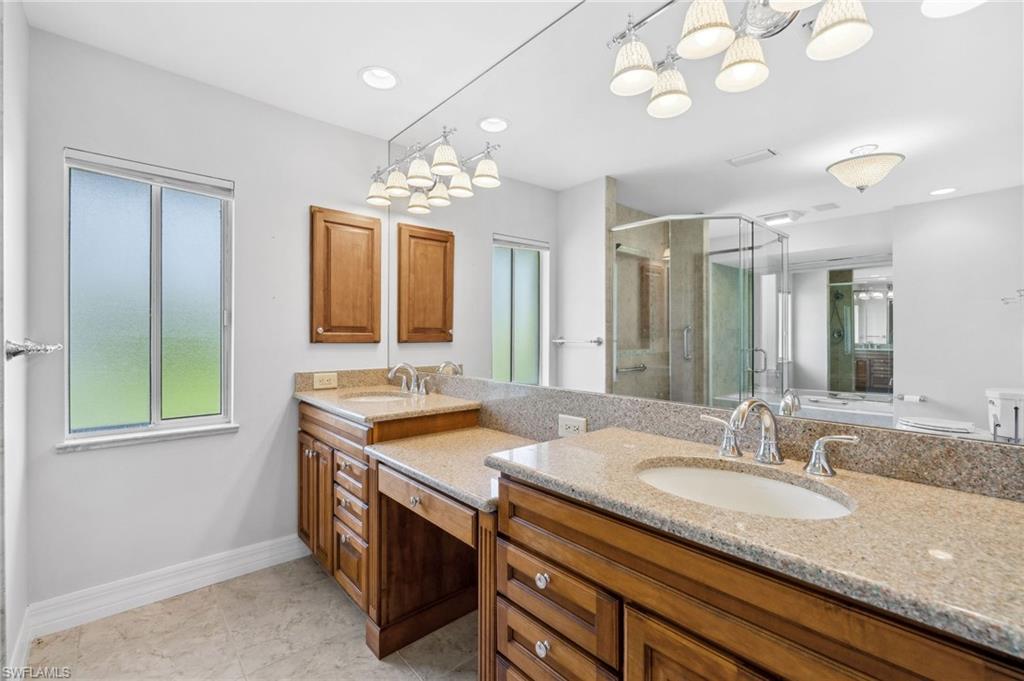 1986 Imperial Golf Course Boulevard Naples, FL 34110 - Photo 18 of 38 a bathroom with a granite countertop sink and a mirror