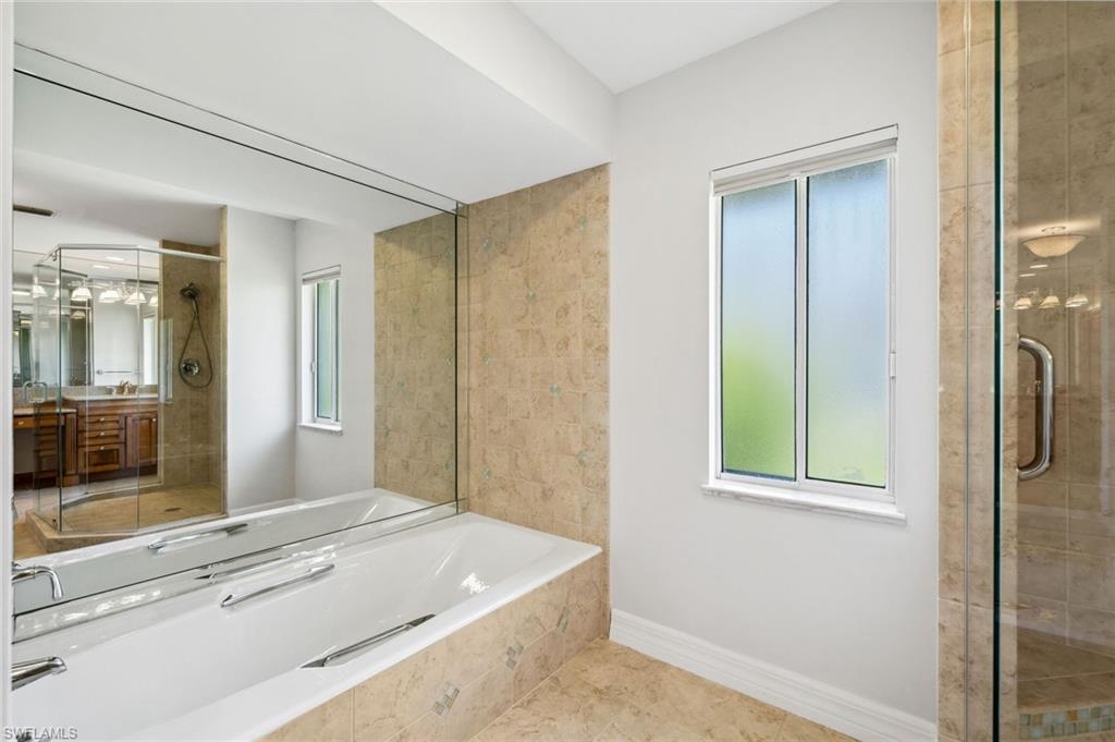 1986 Imperial Golf Course Boulevard Naples, FL 34110 - Photo 19 of 38 a spacious bathroom with a granite countertop sink and a mirror