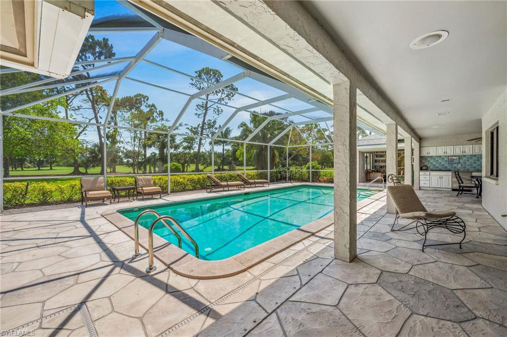 1986 Imperial Golf Course Boulevard Naples, FL 34110 - Photo 30 of 38 a view of a swimming pool with a lounge chairs