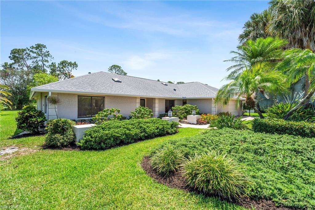 1986 Imperial Golf Course Boulevard Naples, FL 34110 - Photo 33 of 38 a front view of a house with a yard