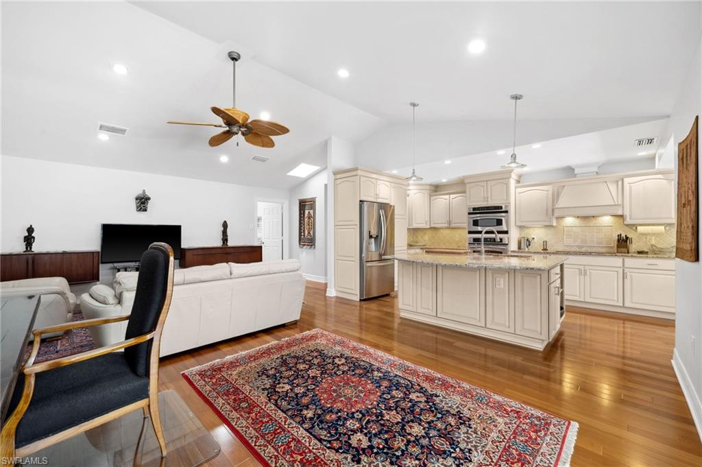 1986 Imperial Golf Course Boulevard Naples, FL 34110 - Photo 9 of 38 a large kitchen with white cabinets and stainless steel appliances