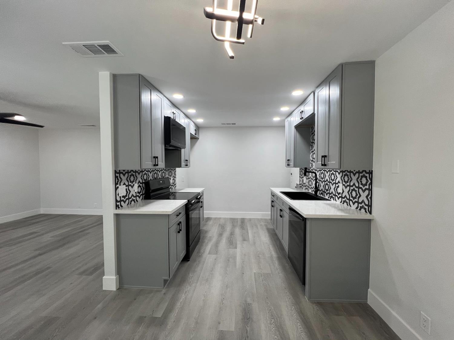 657 West Parlier Avenue, Unit 125 Reedley, CA 93654 - Photo 12 of 25 a kitchen with kitchen island granite countertop a sink cabinets and wooden floor