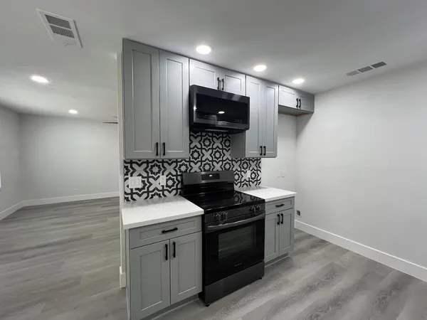 a kitchen with granite countertop a stove and a sink