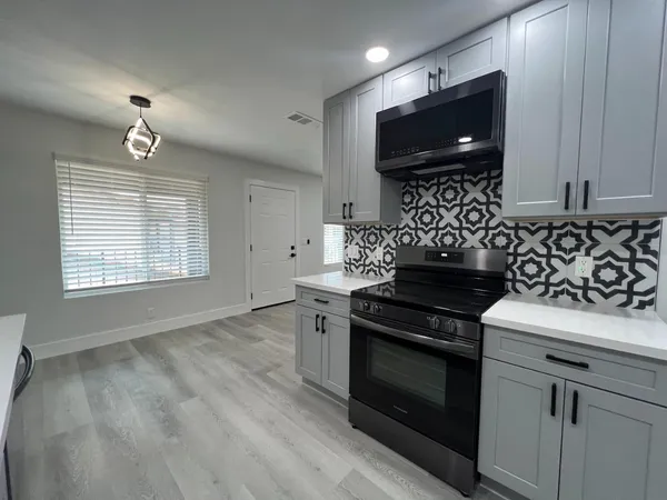 a kitchen with granite countertop a stove and a microwave