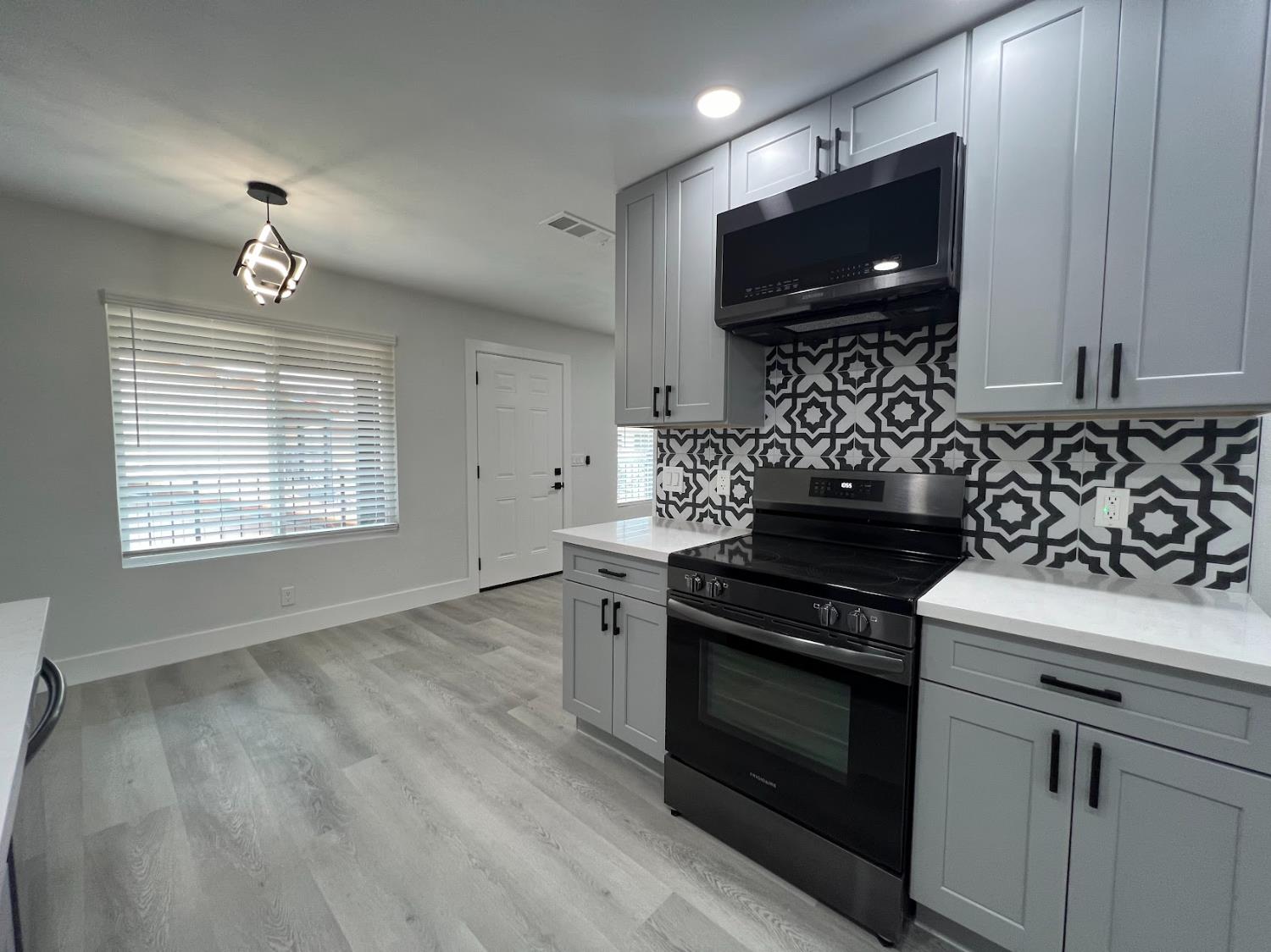 657 West Parlier Avenue, Unit 125 Reedley, CA 93654 - Photo 14 of 25 a kitchen with granite countertop a stove and a microwave