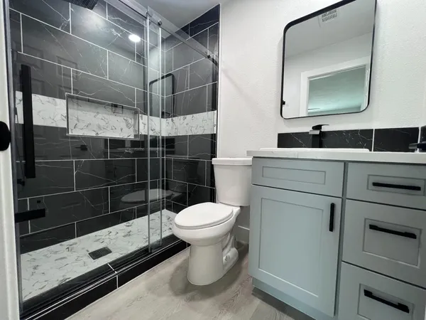 a bathroom with a toilet a sink and mirror