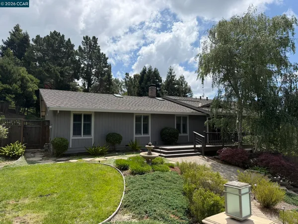 a view of a house with backyard sitting area and garden