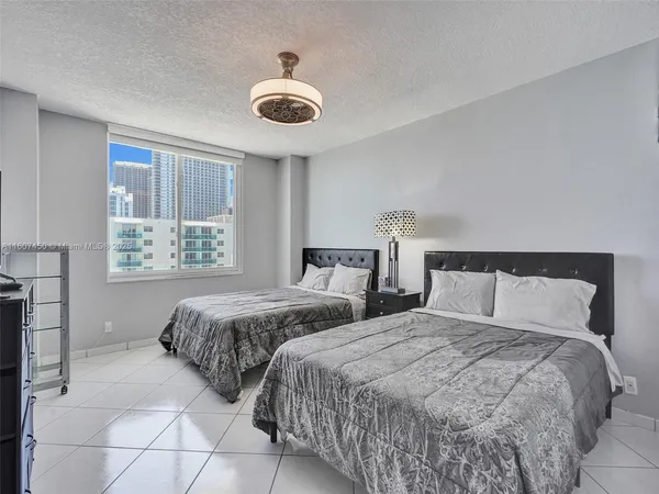 a bedroom with two beds and a large window