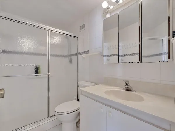 a bathroom with a sink a toilet and a large mirror