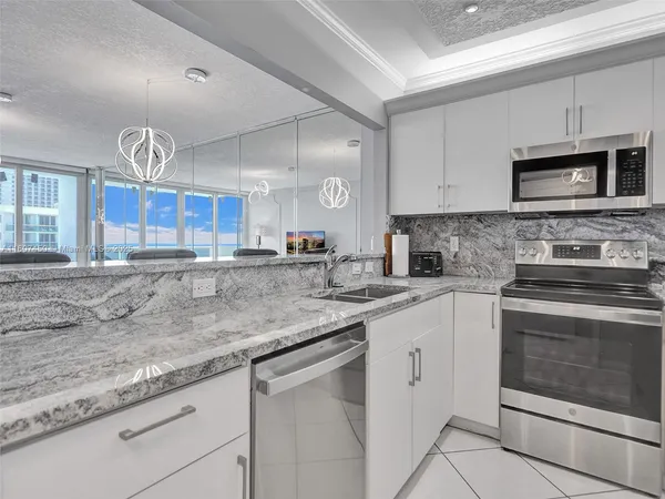 a kitchen with stainless steel appliances granite countertop a sink a stove and cabinets