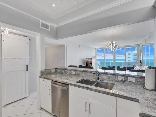 a kitchen with stainless steel appliances granite countertop a sink and a white cabinets