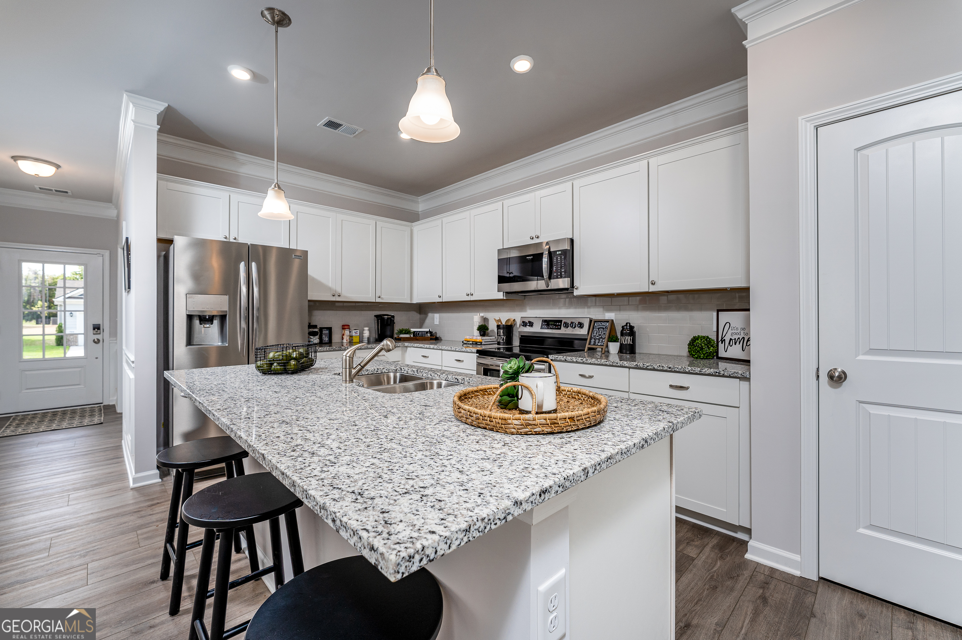 1393 Trellis Court Hampton, GA 30228 - Photo 9 of 25 a kitchen with a sink a stove and chairs