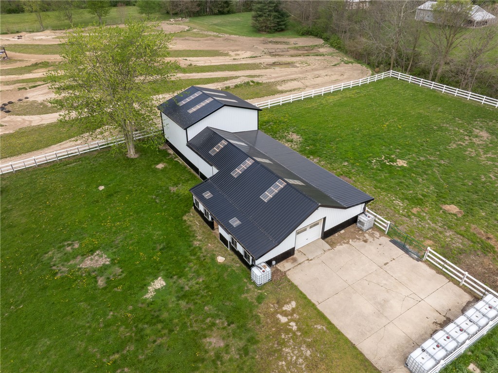 7988 McCool Road Greenville, OH 45331 - Photo 27 of 50 This aerial view showcases a modern barn, surrounded by lush green pastures and pristine white fencing.