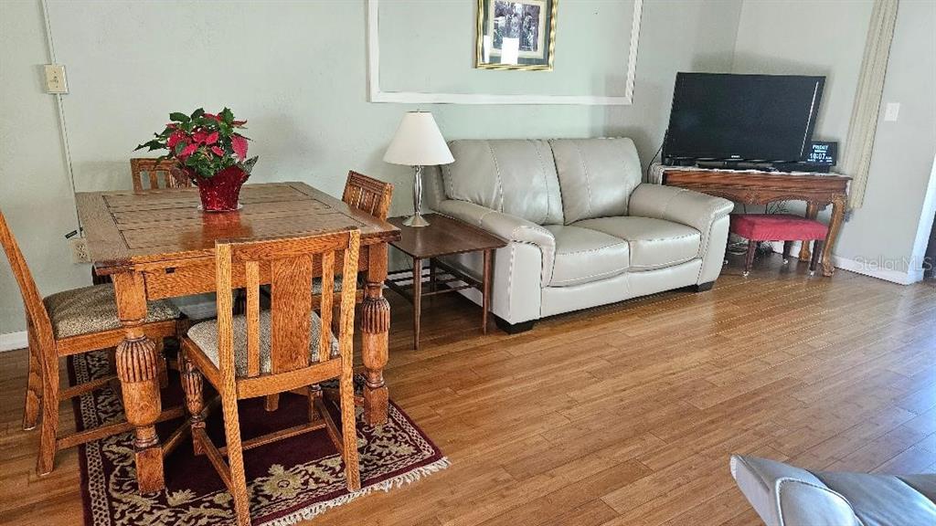 4600 98th Way North, Unit 210 St. Petersburg, FL 33708 - Photo 8 of 33 a living room with furniture a flat screen tv and a table