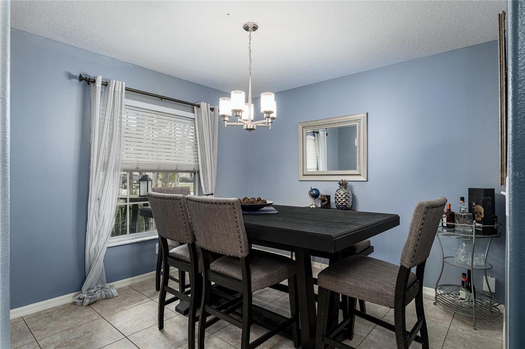 11493 Walden Loop Parrish, FL 34219 - Photo 15 of 30 a dining room with furniture a chandelier and window