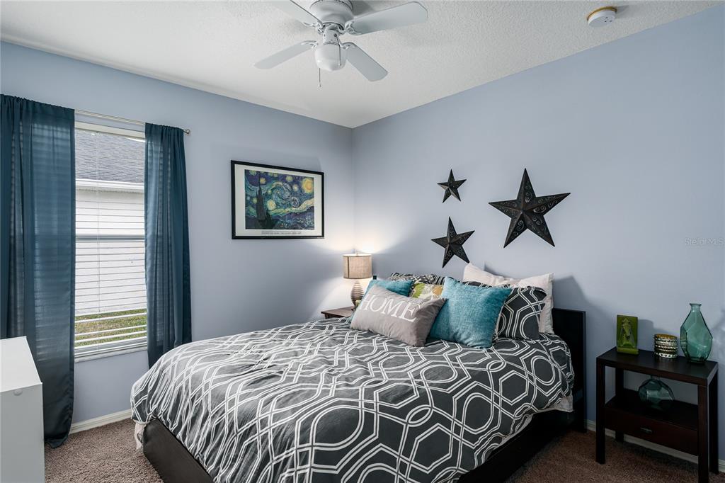 11493 Walden Loop Parrish, FL 34219 - Photo 18 of 30 a bedroom with a bed and a chandelier