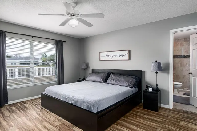 a large bedroom with a large bed and a chandelier fan