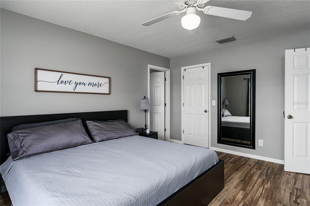 11493 Walden Loop Parrish, FL 34219 - Photo 22 of 30 a bedroom with a large bed and a chandelier