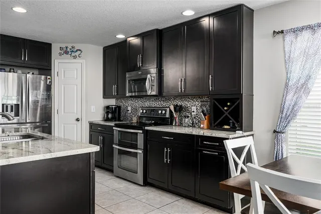 a kitchen with stainless steel appliances granite countertop a stove a sink and a refrigerator