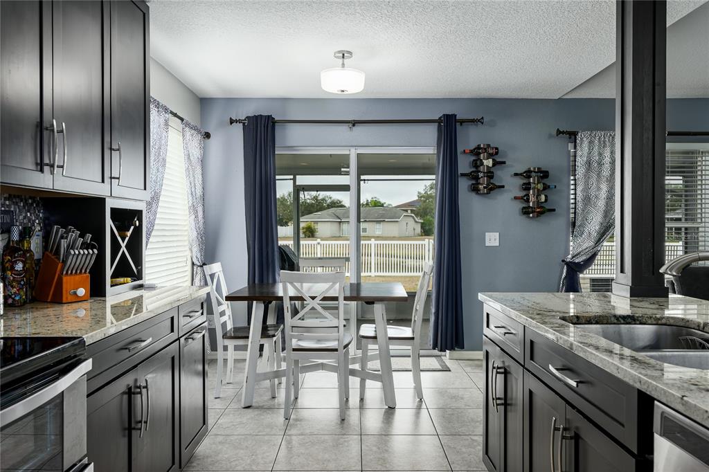 11493 Walden Loop Parrish, FL 34219 - Photo 10 of 30 a kitchen with stainless steel appliances granite countertop a stove a sink and a refrigerator