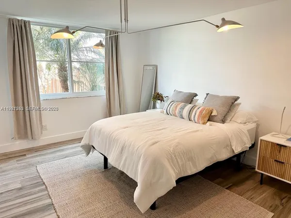 a large bed sitting in a bedroom next to a window