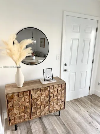 a bedroom with a bed a mirror and lamp