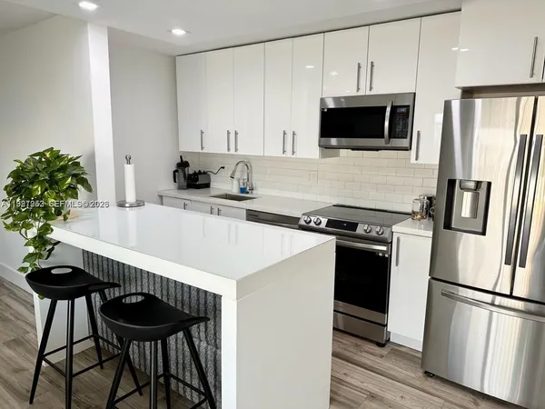 a kitchen with stainless steel appliances a stove a sink and a refrigerator