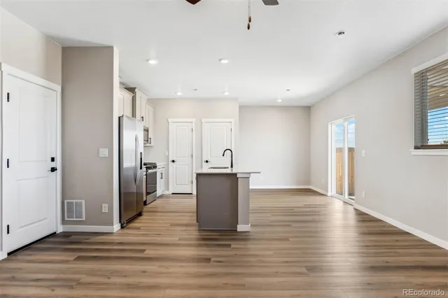 a view of a big room with wooden floor and windows