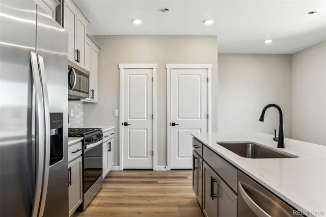 a kitchen with stainless steel appliances granite countertop a refrigerator and a sink