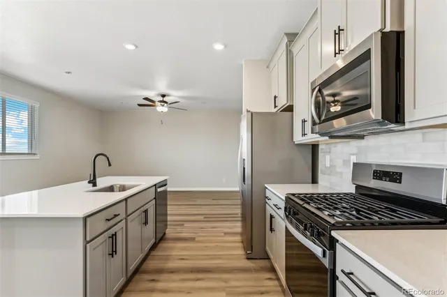 a kitchen with stainless steel appliances a sink stove and microwave