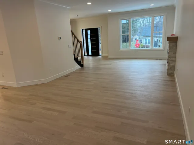 a view of staircase with wooden floor and white walls