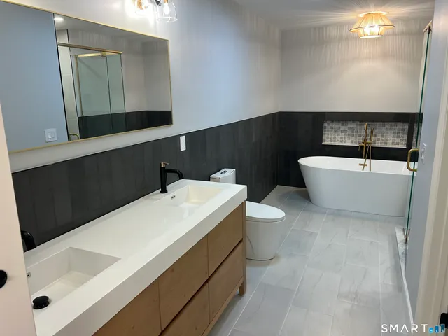 a bathroom with a sink a toilet and shower