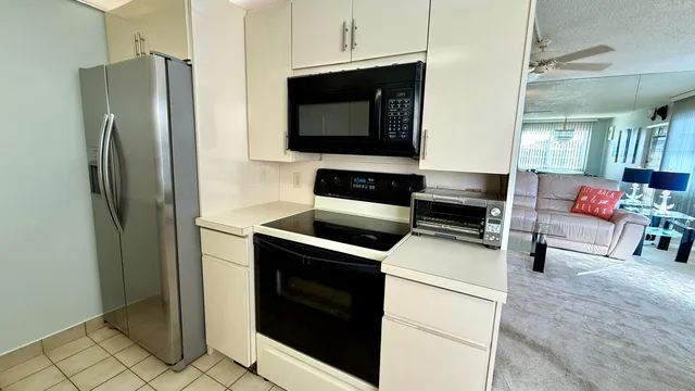 a living room with furniture a flat screen tv and a large window