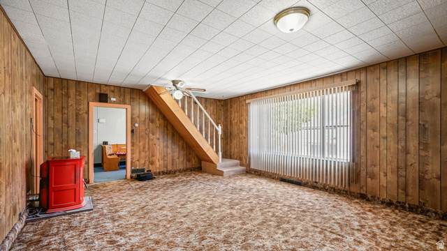 44 Shriver Street Eureka, UT 84628 - Photo 7 of 43 Living area with wood paneling, acoustic tile ceiling, and a carpeted floor