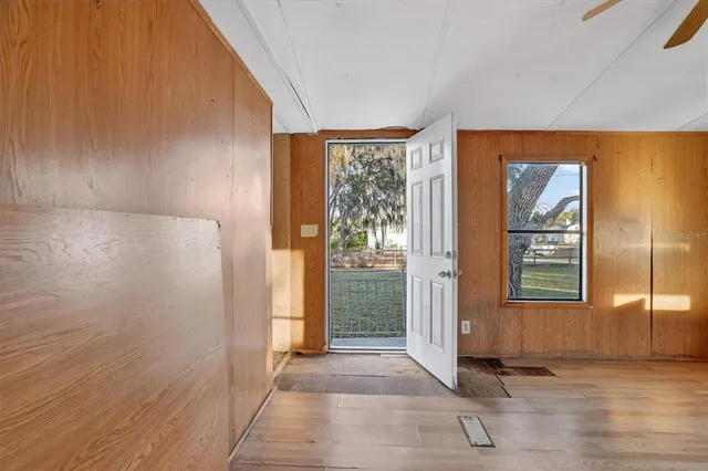 a view of empty room with wooden floor and fan