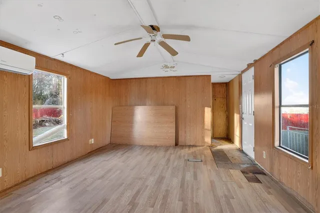 a view of a big room with wooden floor and windows