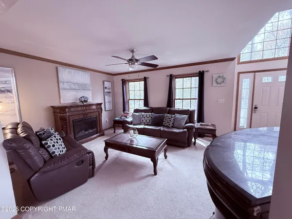 a living room with furniture a fireplace and a large window