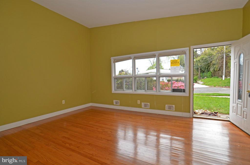 4618 Tema Road Pikesville, MD 21208 - Photo 3 of 29 a view of an empty room with a window and wooden floor