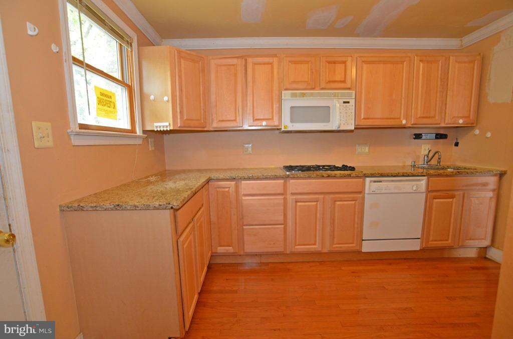 4618 Tema Road Pikesville, MD 21208 - Photo 7 of 29 a kitchen with stainless steel appliances granite countertop a sink stove and cabinets