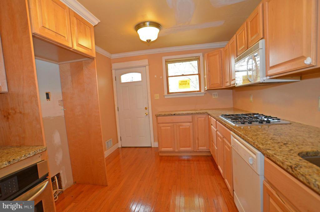 4618 Tema Road Pikesville, MD 21208 - Photo 8 of 29 a kitchen with a wooden floor and a stove top oven