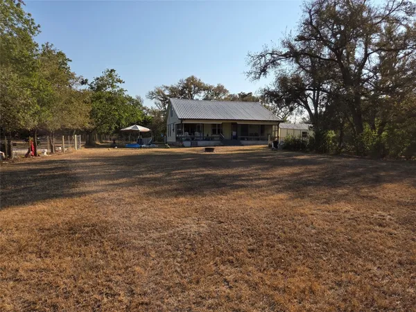 a front view of a house with a yard and trees