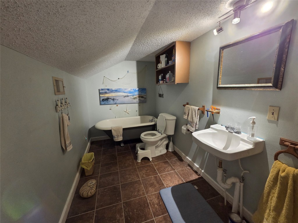 150 Beaver Road Elgin, TX 78621 - Photo 30 of 40 a bathroom with a toilet sink and mirror