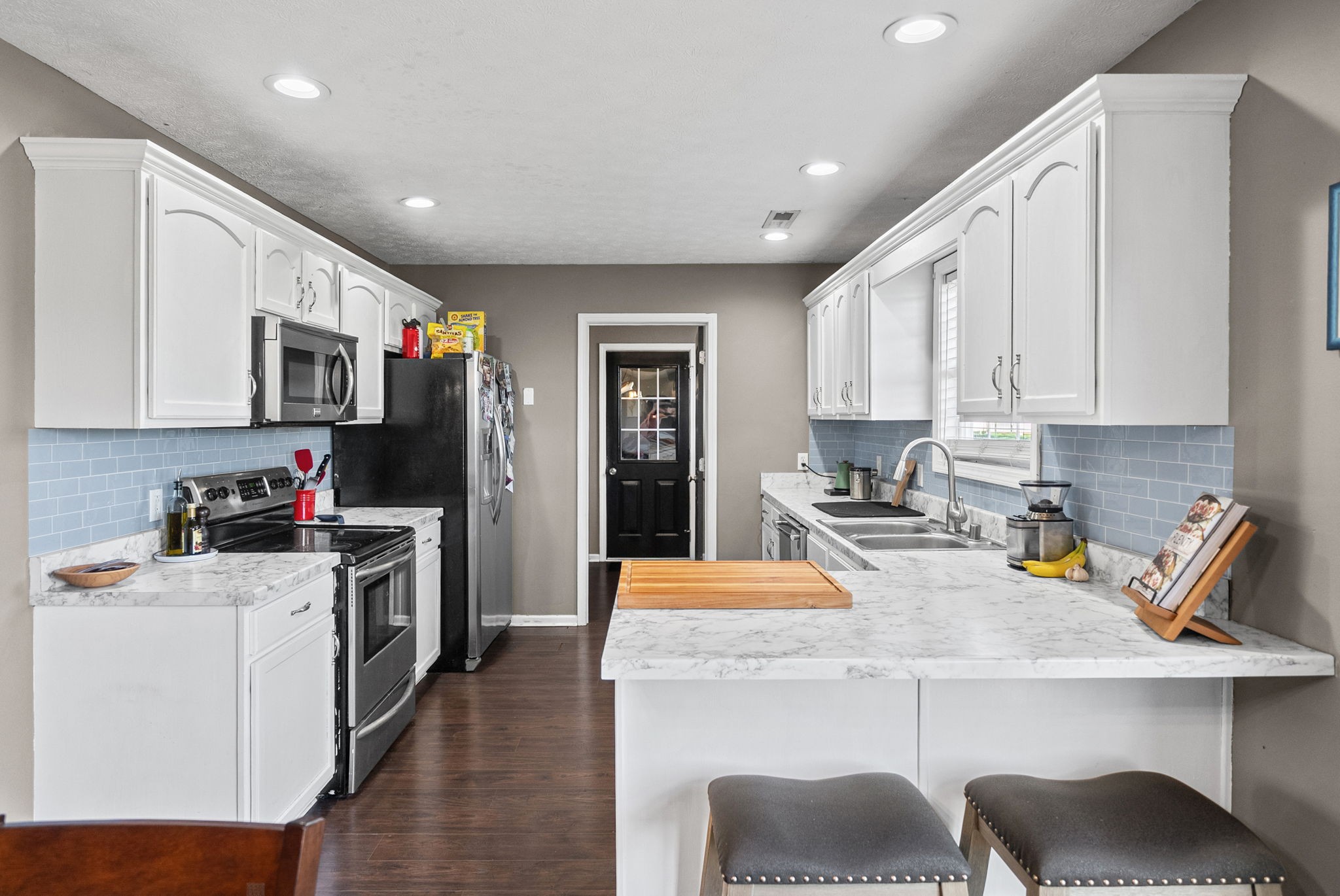 1940 Loop Lane Gracey, KY 42232 - Photo 9 of 32 a kitchen with a sink a stove and white cabinets