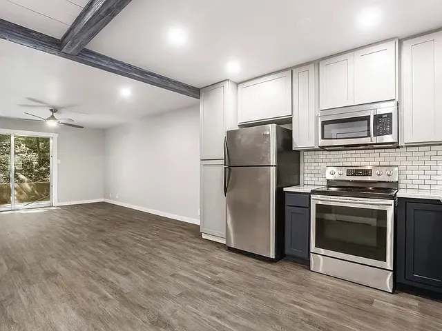 a kitchen with stainless steel appliances granite countertop a refrigerator microwave and stove