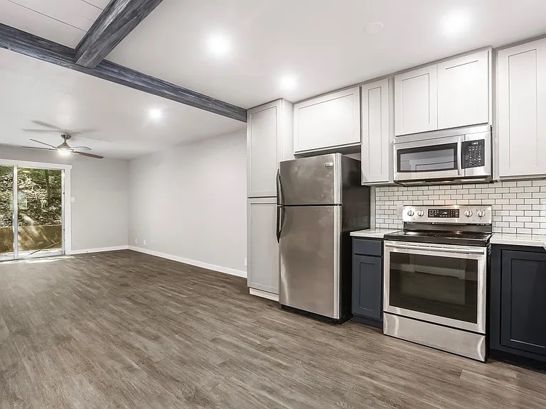 5330 Balcones Drive, Unit C Austin, TX 78731 - Photo 1 of 6 a kitchen with stainless steel appliances granite countertop a refrigerator microwave and stove