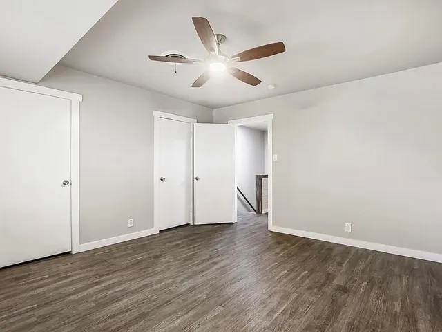 a view of an empty room with wooden floor