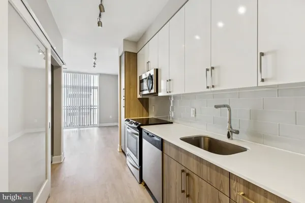 a kitchen with stainless steel appliances granite countertop a sink and a refrigerator