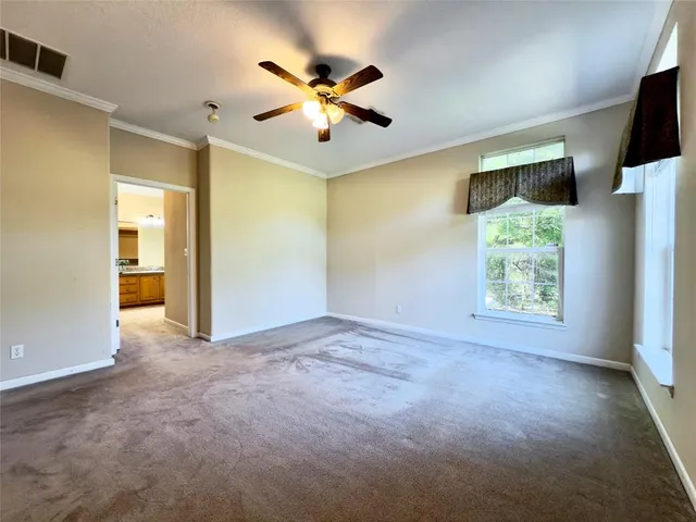 a view of empty room with window fan and ceiling fan