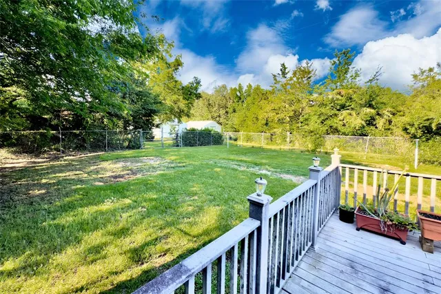 a view of a deck and yard with wooden fence