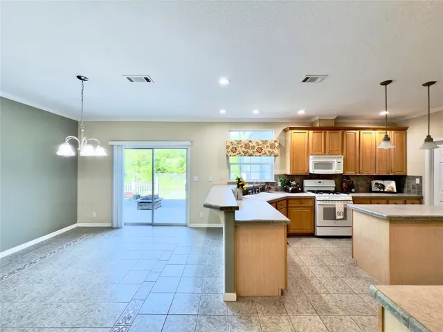 a kitchen with counter top space appliances and windows